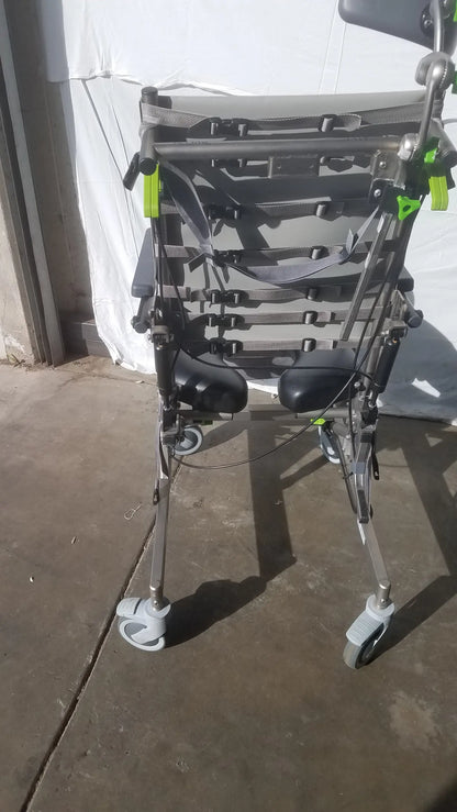 Gray and black raz attendant tilt shower commode chair with adjustable straps green clips and four wheels for support