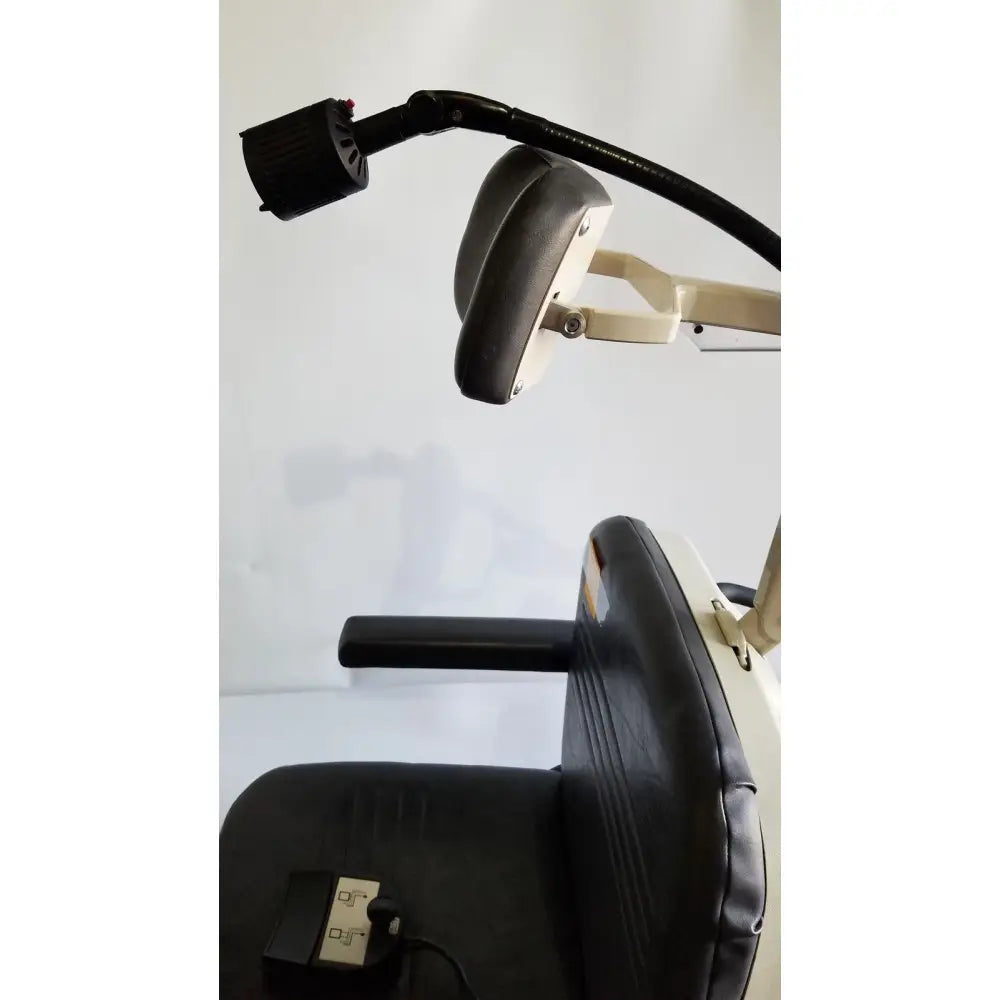 Black padded headrest with adjustable arm and beige metal frame attached to reliance medical products model 6100 exam chair