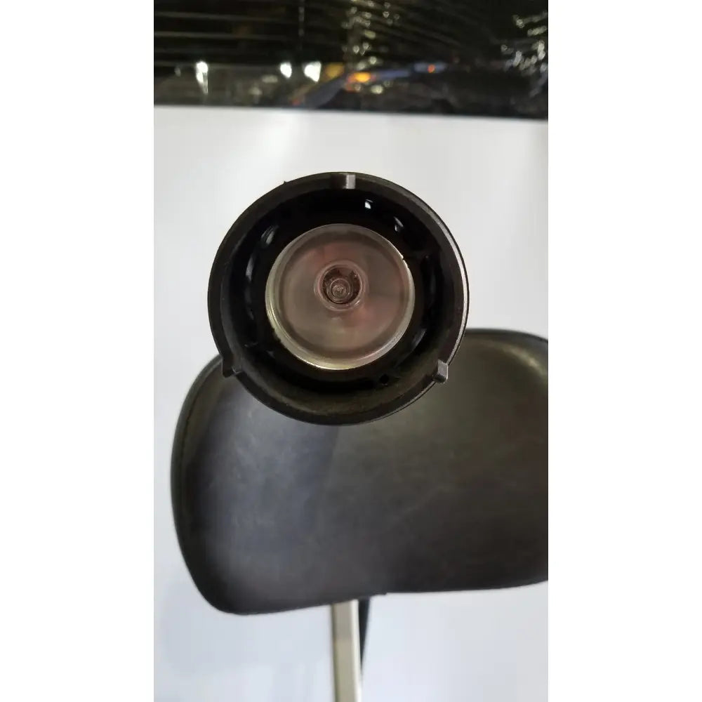 Black circular head of reliance medical products model 6100 exam chair with metallic central component and headlight
