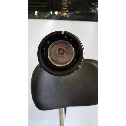 Black circular head of reliance medical products model 6100 exam chair with metallic central component and headlight