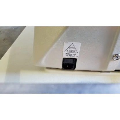 Beige plastic power supply unit with black plug and safety label on the back of reliance medical products model 6100 exam chair