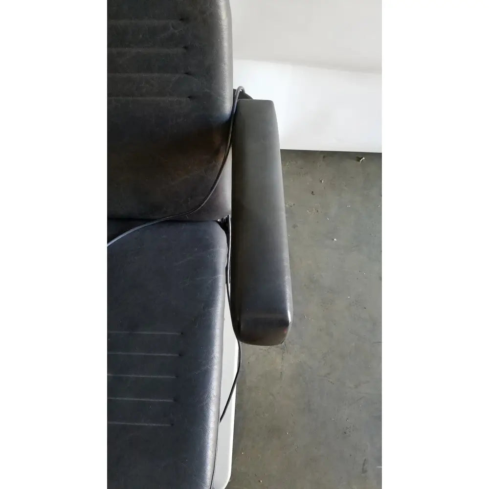 Black leather padded armrest with visible stitching on the reliance medical products model 6100 exam chair