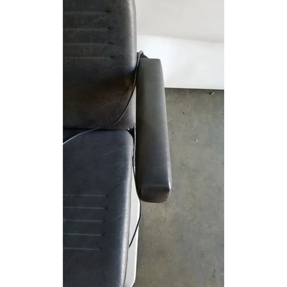 Black leather padded armrest with visible stitching on the reliance medical products model 6100 exam chair