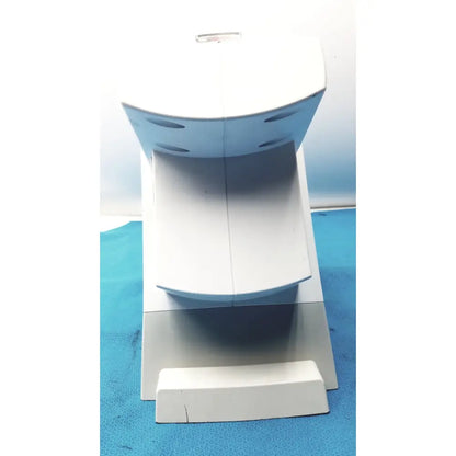 White plastic model of a toilet with curved seat and circular cutouts used with renfert sympress impression mixing machine