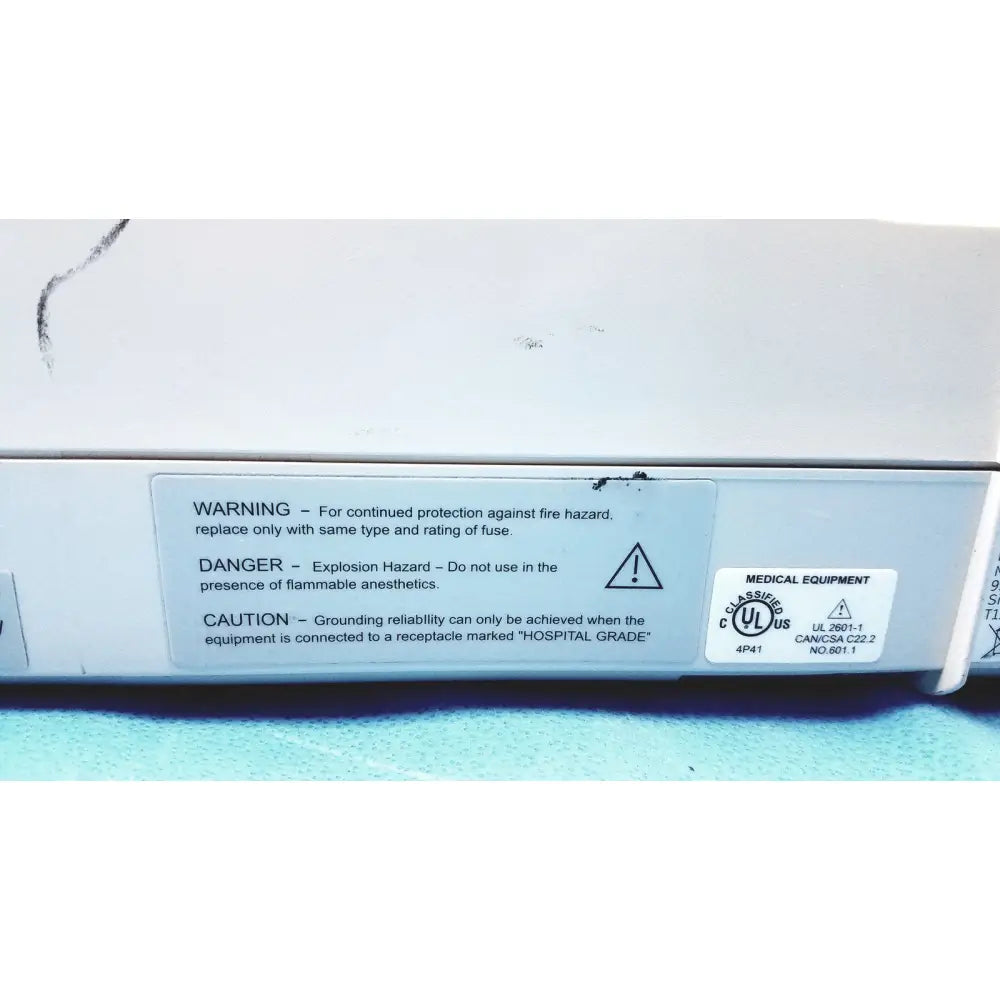 White medical equipment with gray label showing safety warnings and certification marks for mac1200 ekg machines repair service