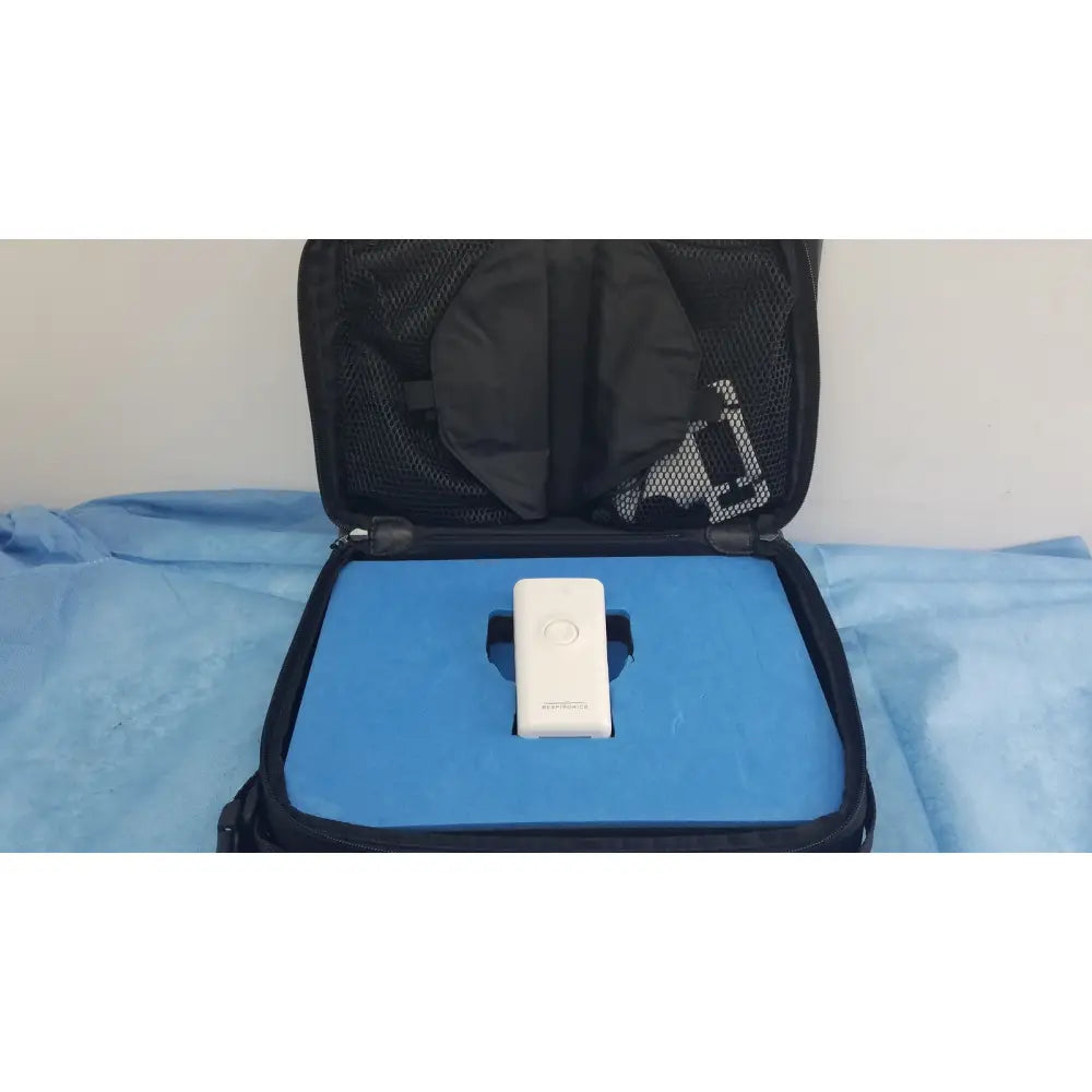 White rectangular respironics alice pdx portable sleep diagnostic system with circular button in black mesh travel case