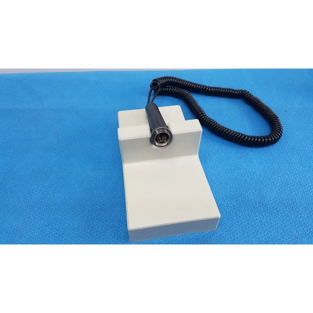 White plastic diagnostic station extension module with black coiled cable and metallic connector for ri-former handle