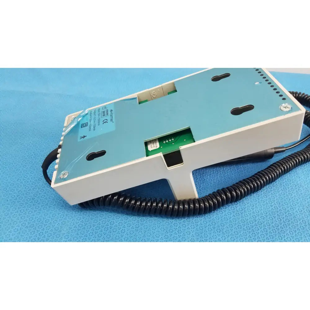 Back side of ri-former diagnostic station extension module 1 handle in white and light blue with black coiled cable and green circuit board visible