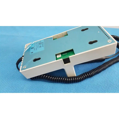 Back side of ri-former diagnostic station extension module 1 handle in white and light blue with black coiled cable and green circuit board visible