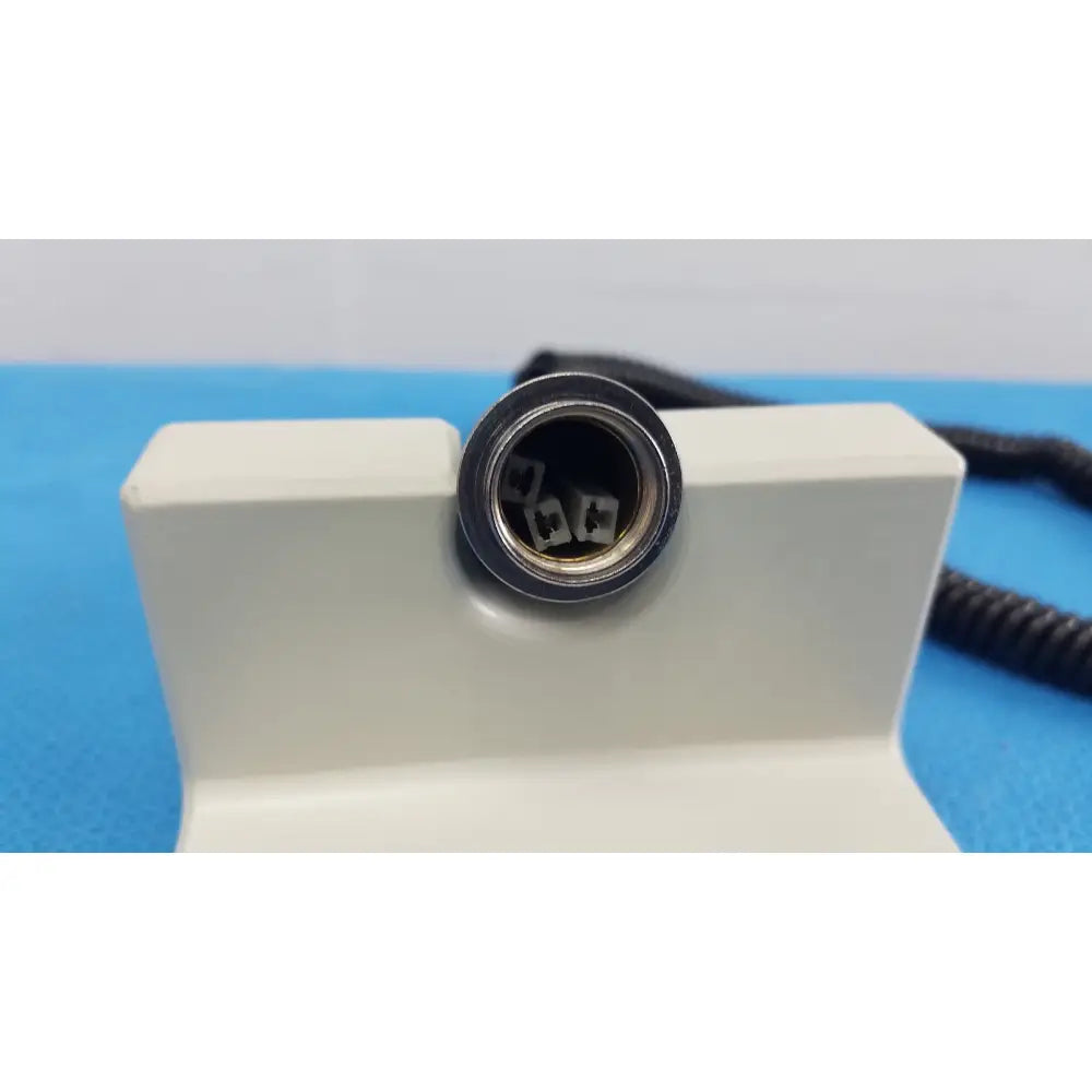 Black circular connector with metallic inner components on white plastic housing of ri-former diagnostic station extension module