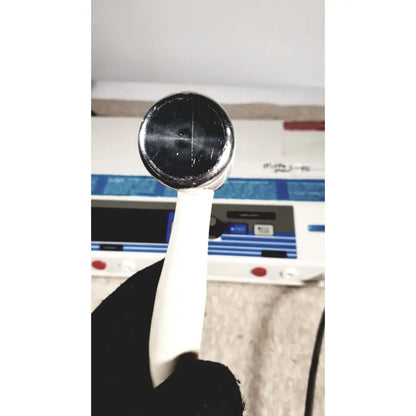 Silver-toned round-headed handheld device with white plastic handle from rich-mar theramini 3c combo ultrasound electrical unit