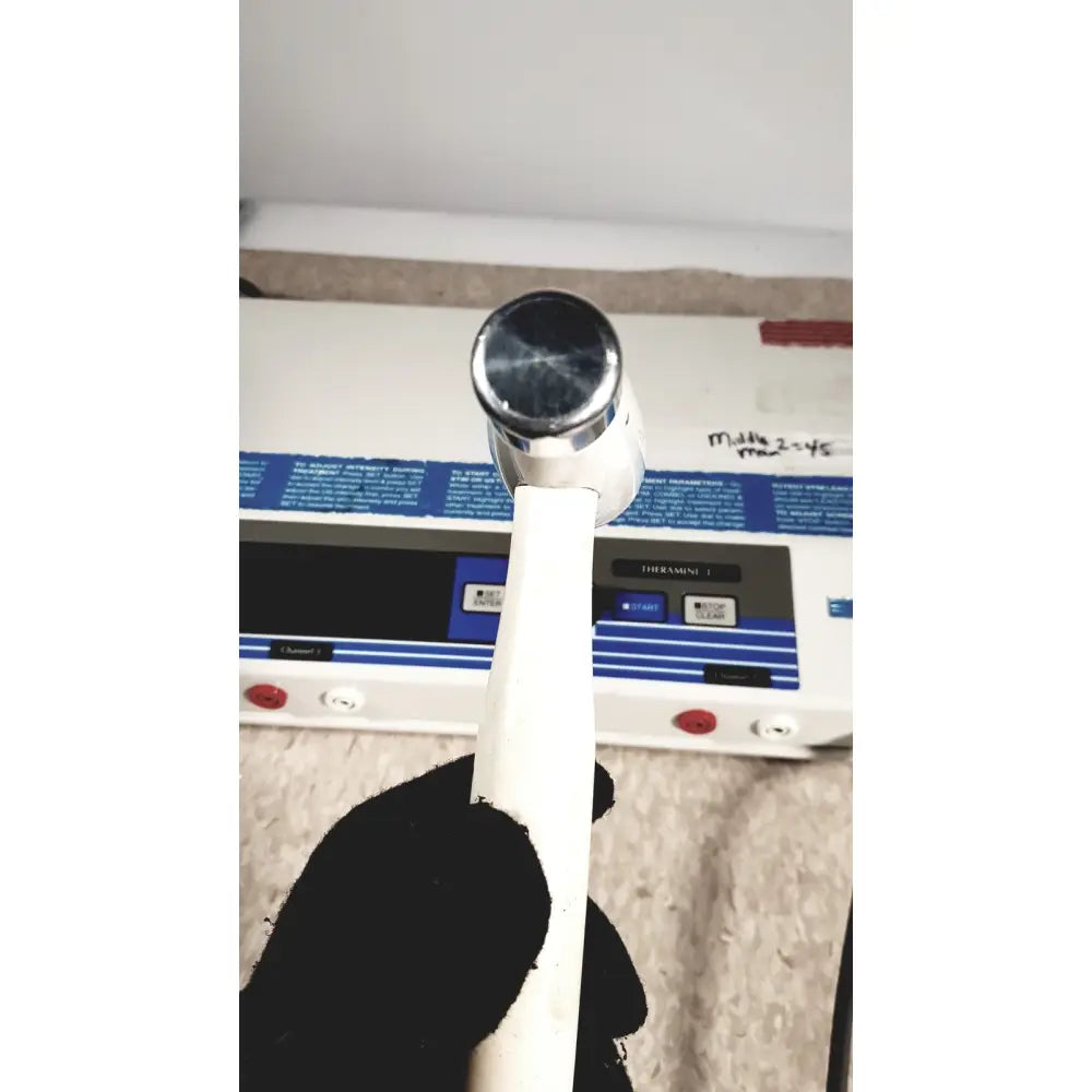 A white-handled hammer with a chrome head held in black gloves for the rich-mar theramini 3c combo ultrasound electrical unit