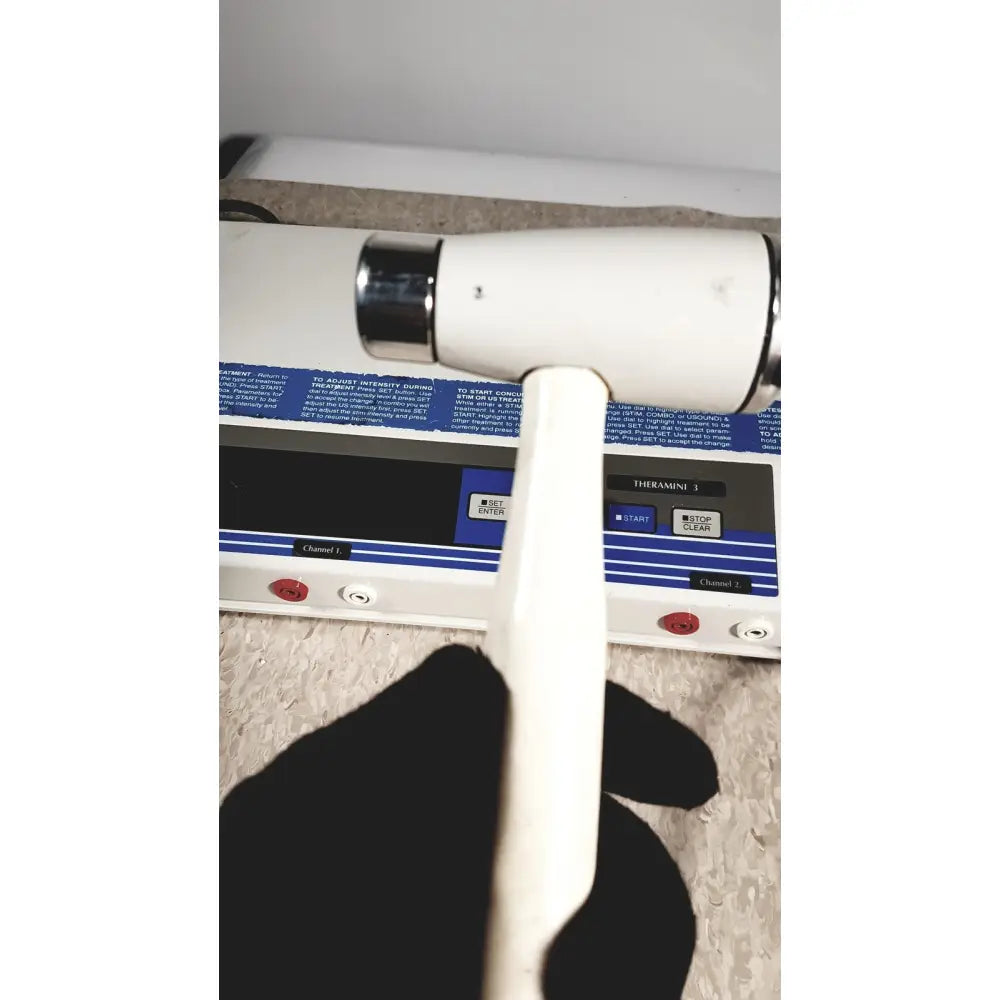 White handle with black grip and chrome accents on rich-mar theramini 3c combo ultrasound electrical stimulation unit
