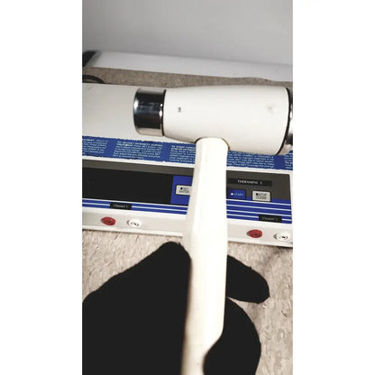 White handle with black grip and chrome accents on rich-mar theramini 3c combo ultrasound electrical stimulation unit