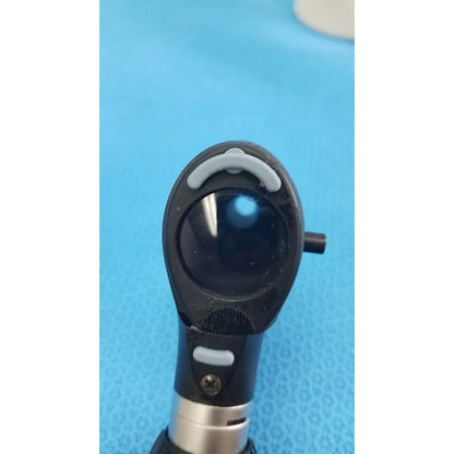 Black and silver otoscope with curved gray handle grip on riester ri-charger l charging base for medical use