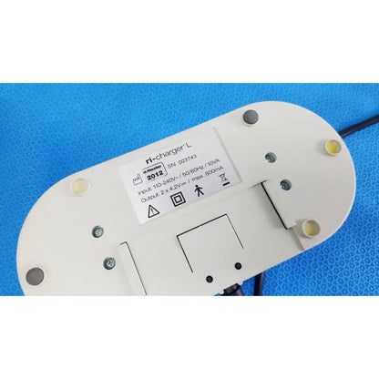 White oval-shaped ri-charger l charging base with four yellow indicator lights and reuse medical technical label