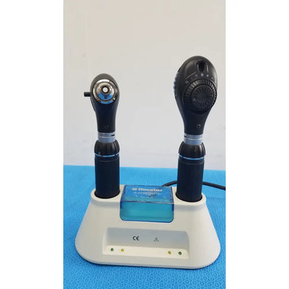Two black riester ri-charger l charging otoscopes with textured grips and silver accents in white charging base