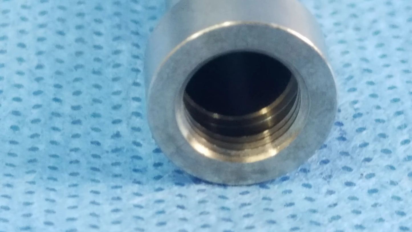 Silver-colored metal fiber interface adapter connector with smooth cylindrical exterior and visible internal threading for optical fiber