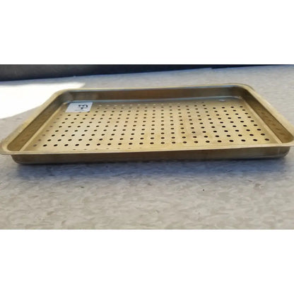 Gold-colored metal ritter autoclave sterilizer tray with evenly spaced perforations for effective sterilization
