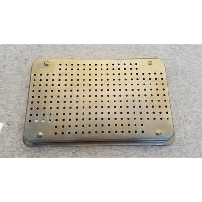 Rectangular brass-colored metal ritter autoclave sterilizer tray with circular perforations and rounded corners