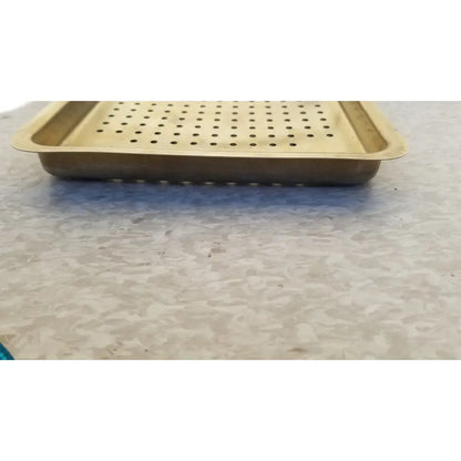 Gold-colored metal ritter autoclave sterilizer tray with perforated surface and raised edges for sterilization use