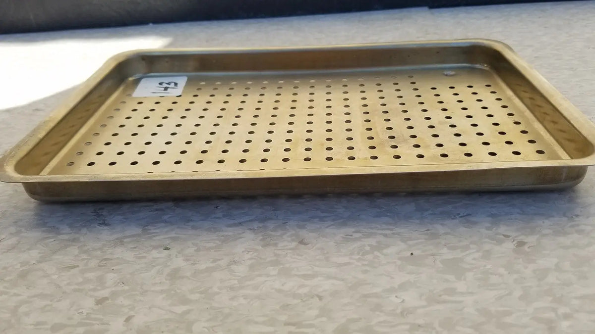Gold-colored metal ritter autoclave sterilizer tray with evenly spaced perforations for effective sterilization