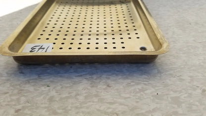 Gold-colored metal ritter autoclave sterilizer tray with evenly spaced perforations and raised edges for sterilization use