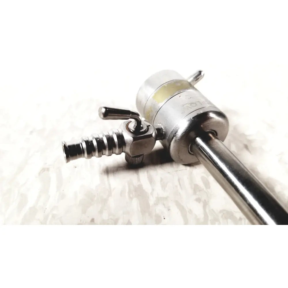 Silver rotating single stopcock cannula with threaded metallic shaft and engraved cylindrical handle for precise control