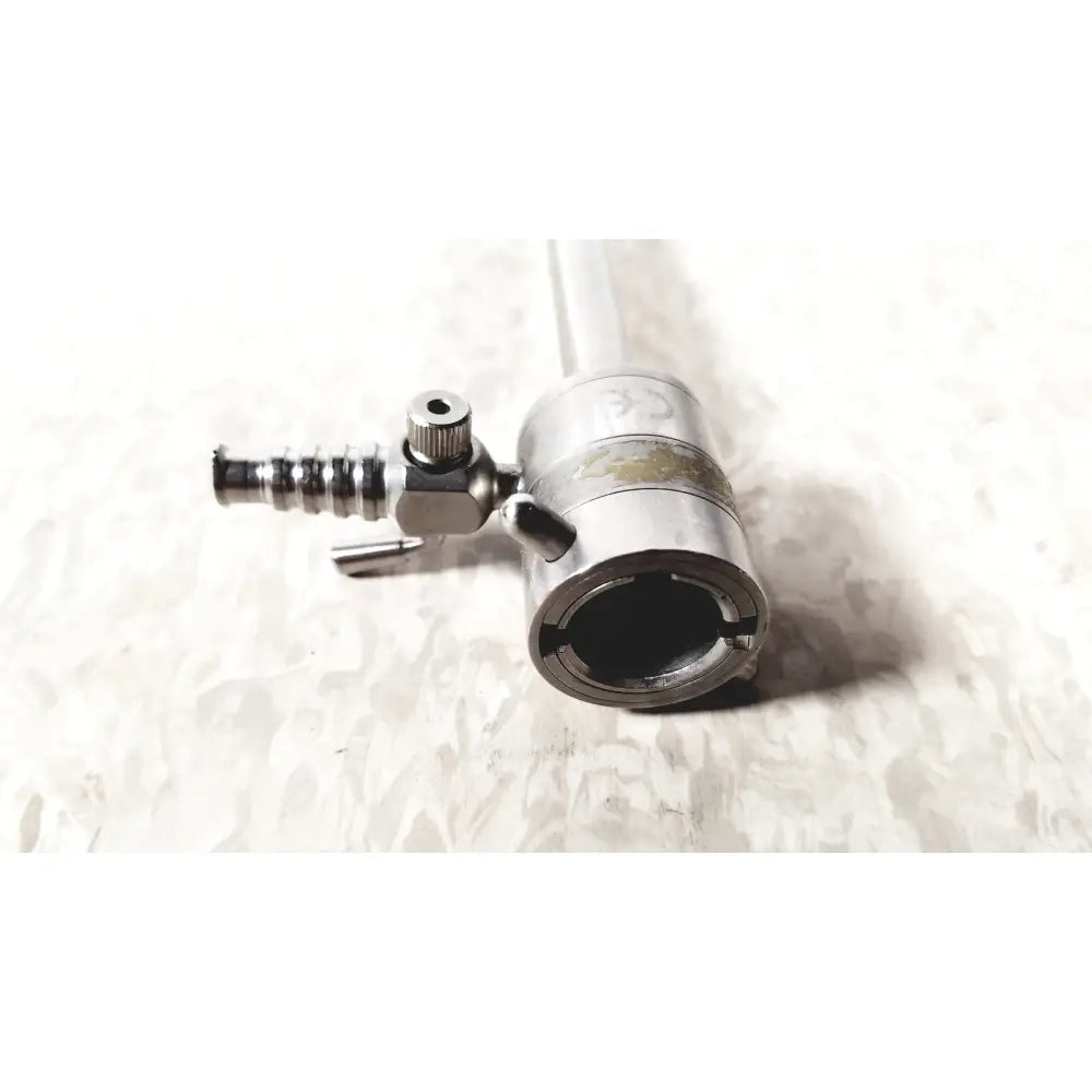 Silver metallic rotating single stopcock cannula with threaded valve and cylindrical body for precise fluid control