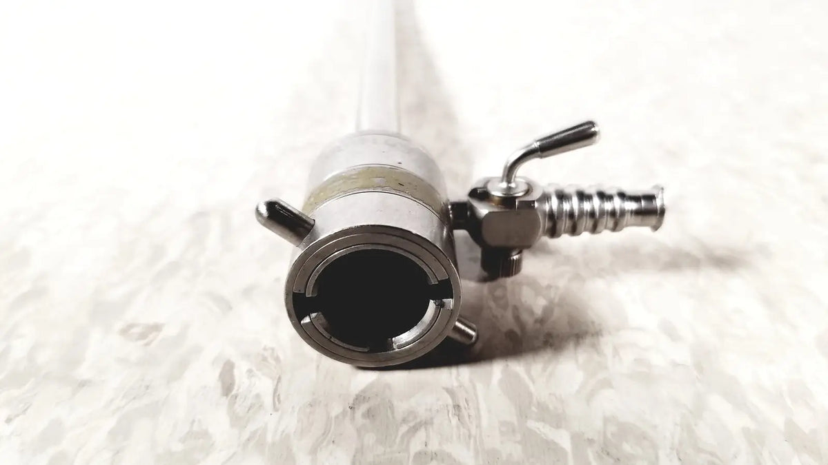 Silver metallic rotating single stopcock cannula with cylindrical body, threaded connections, and small lever mechanism