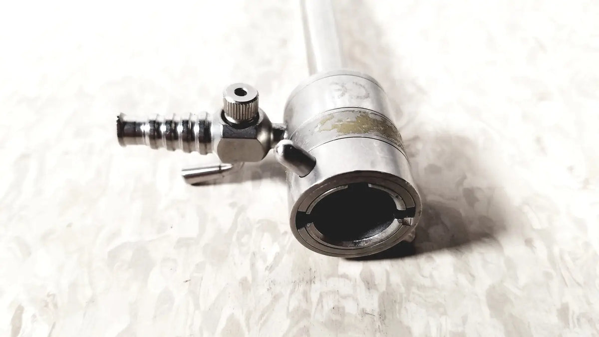 Silver metallic rotating single stopcock cannula with threaded valve and cylindrical body for precise fluid control