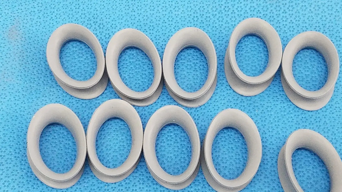 Gray silicone rubber ring gaskets arranged on a blue surface for reuse medical applications front and back view