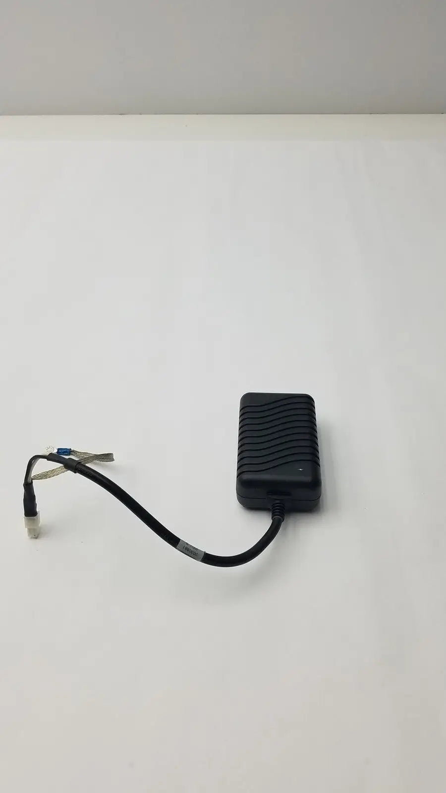 Black plastic safety mark 2403srm 30 charger with textured ribbed surface and coiled cable ending in connector