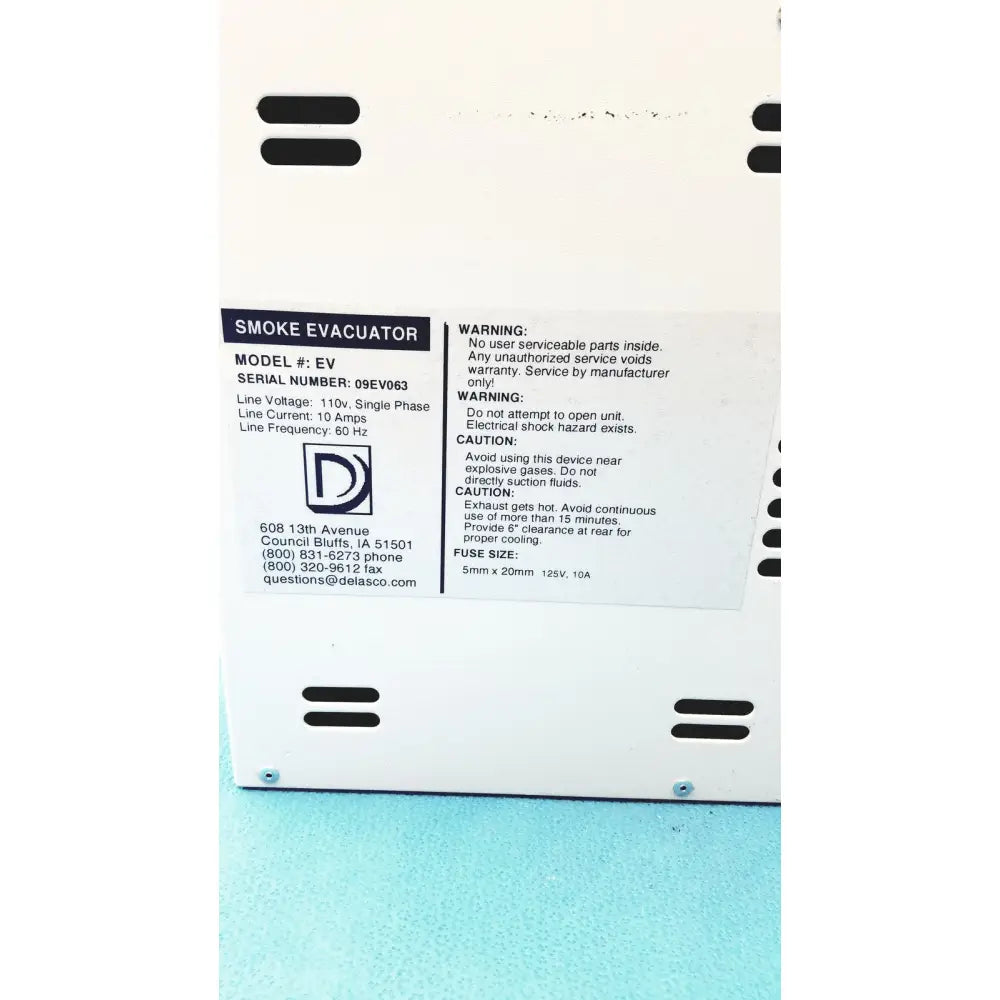 White plastic safevac smoke evacuator with black ventilation slits and technical specifications label visible on the back side