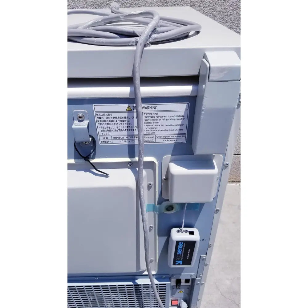 Gray coiled refrigerant hose on light gray industrial air conditioning unit of sanyo vip series ultra low freezer back side