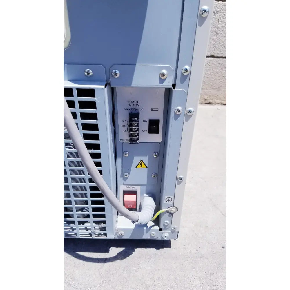 Light gray industrial power distribution panel with red toggle switch on sanyo vip series ultra low temperature freezer