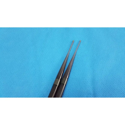 A pair of sleek dark brown savary gilliard dilator cook endoscope 19mm drumsticks with metallic silver bands near handles