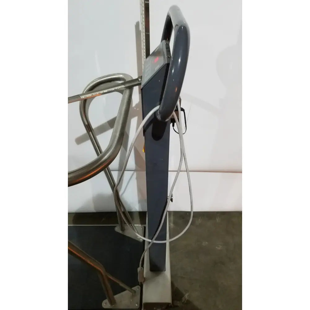 Dark gray metal ticket gate with curved handle and visible wiring shown on the back of a patient medical portable digital scale