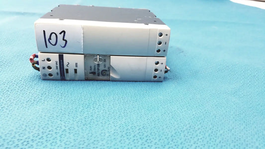 Silver industrial switch mode din rail panel mount power supply stacked with one labeled 103 schneider electric abl7 rp1205