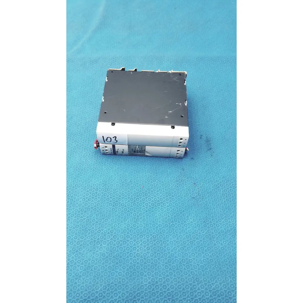 Silver and black car stereo with digital display paired with schneider electric abl7 rp1205 switch mode power supply panel mount