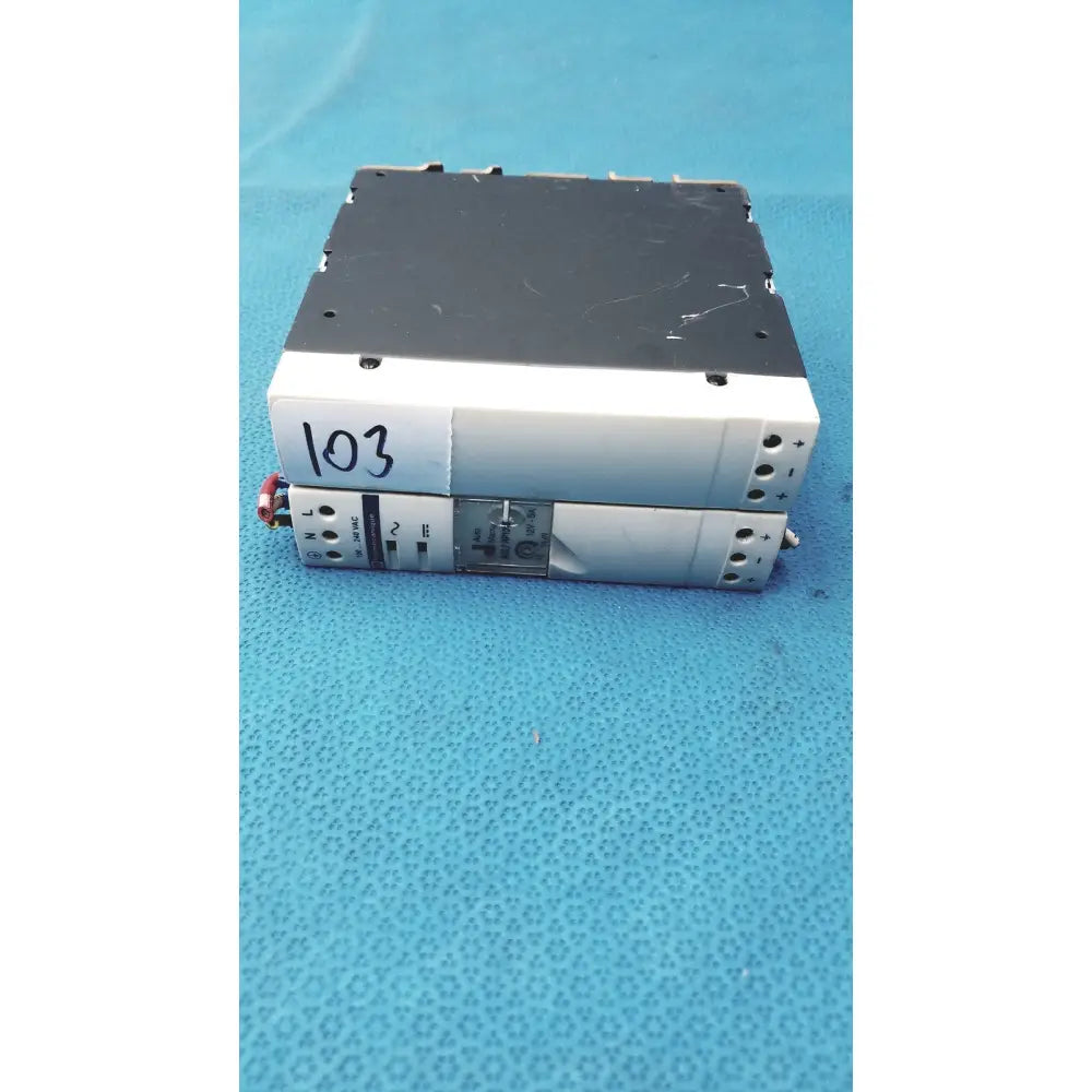 Stacked schneider electric abl7 rp1205 switch mode din rail power supplies with white and black casings and labeled terminals