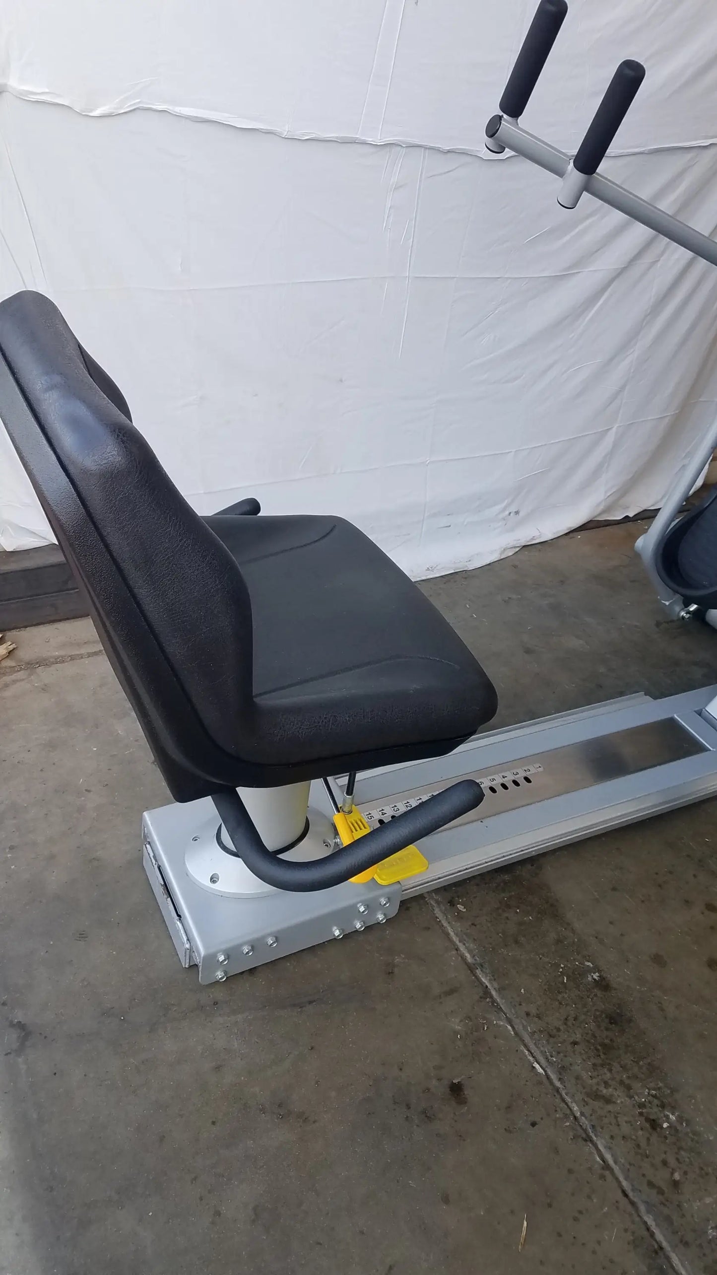 Black padded seat with silver metal frame and black handlebars of scifit systems rst7000 recumbent stepper