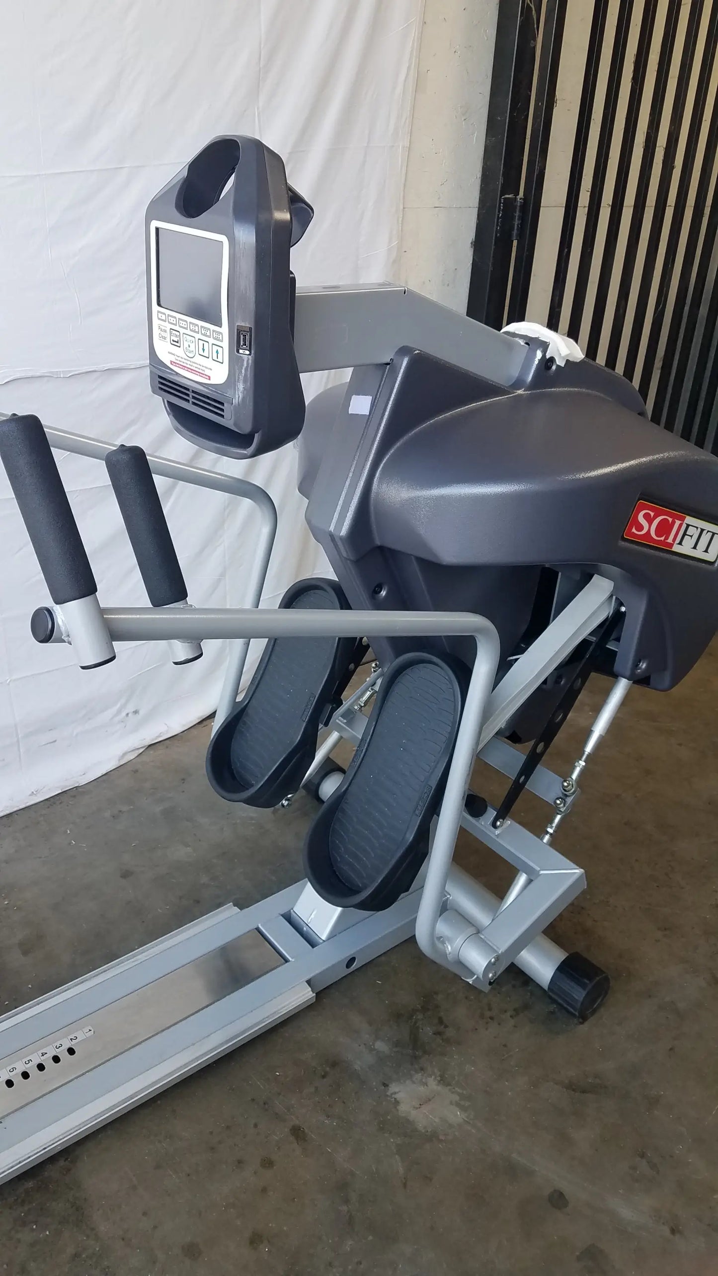 Gray and black Scifit Systems RST7000 recumbent stepper with handlebars-mounted digital display screen for fitness use