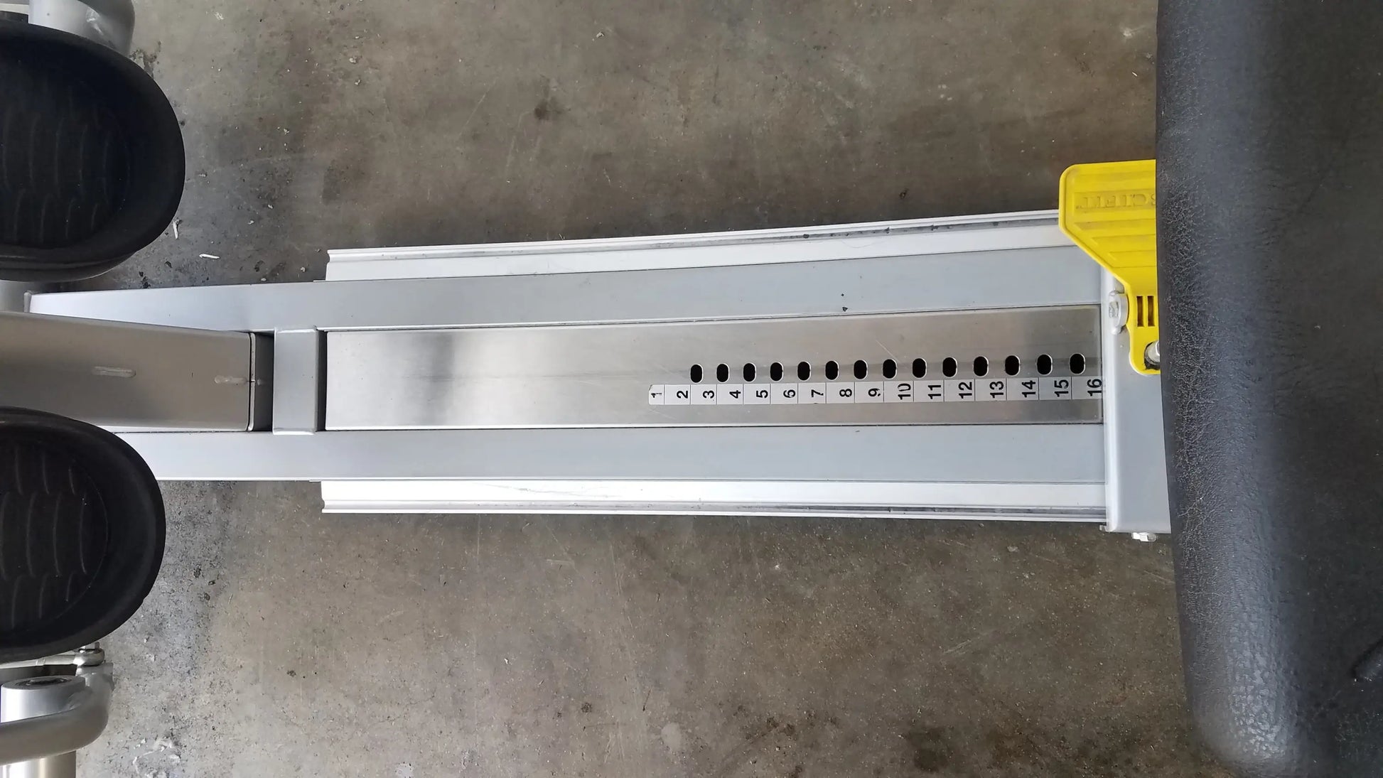 Silver metallic track of scifit systems rst7000 recumbent stepper with black foot pedals and yellow adjustment lever