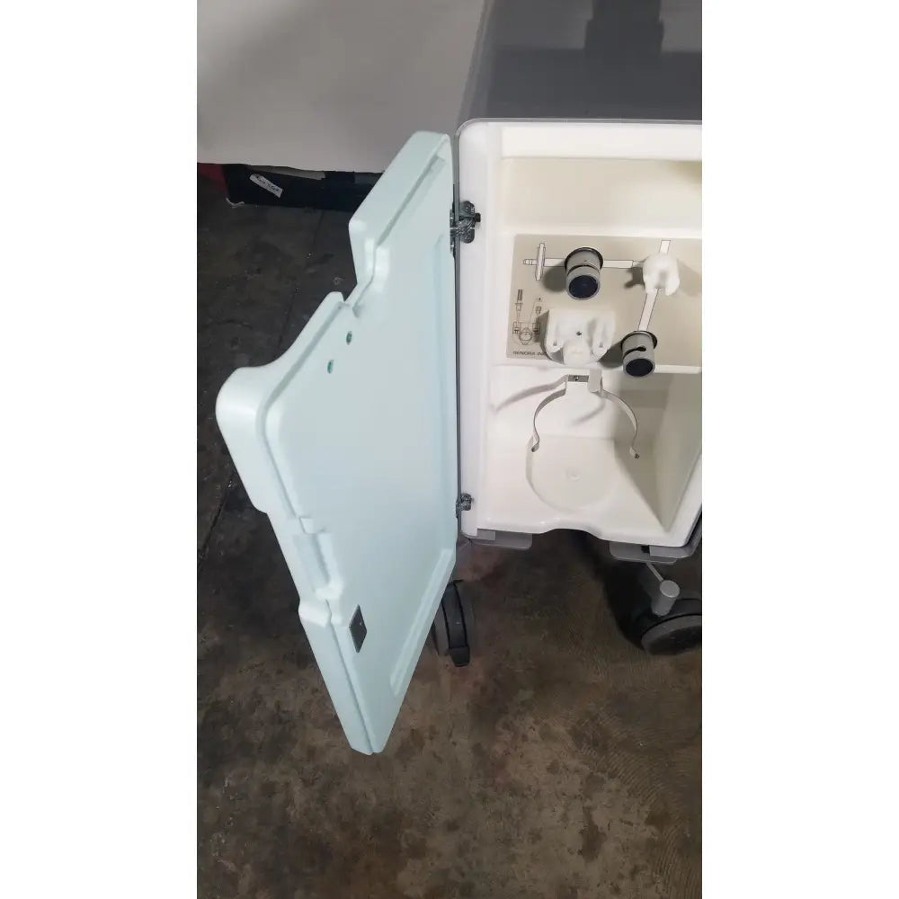 White plastic senorx cm3000 control module medical cart with open lid showing internal compartments and tubing for encor breast biopsy