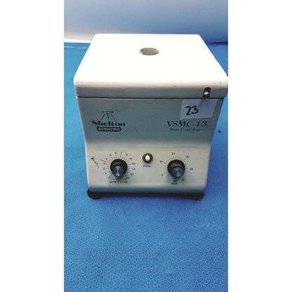 White plastic shelton scientific vsmc-13 benchtop laboratory centrifuge with two rotary dials and central pulse button