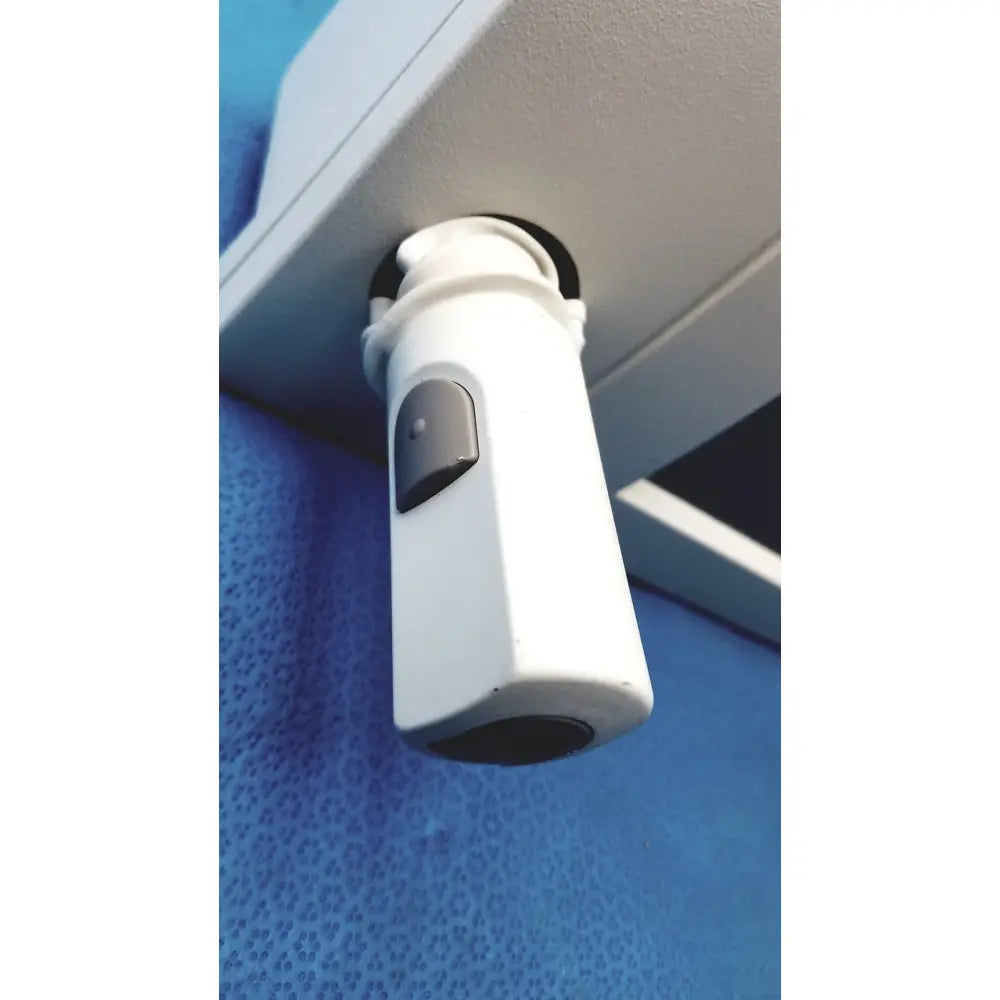 Siemens 07558831 ipx4 control console with white cylindrical security camera and gray button mounted under overhead surface
