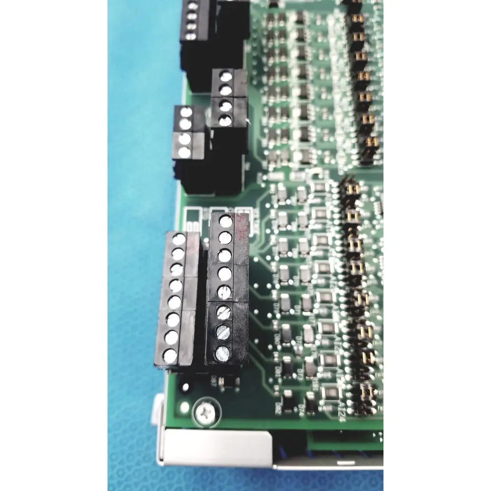 Green printed circuit board with black terminal blocks and silver soldered components of siemens apogee automation controller
