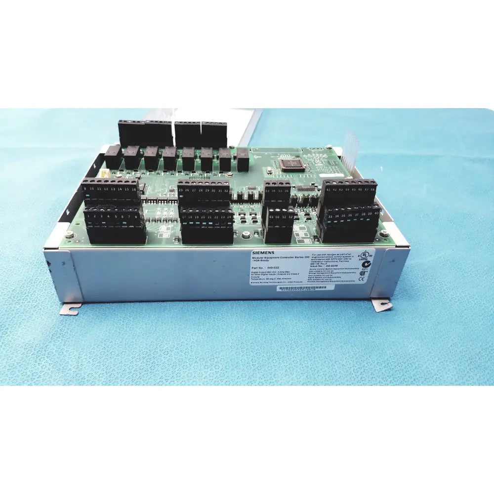 Silver metallic siemens apogee automation modular equipment controller with black connectors and green circuit board