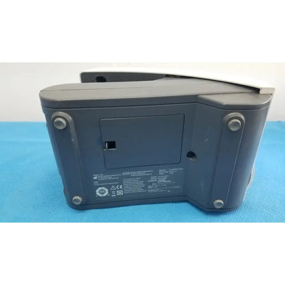 Back side of dark gray plastic siemens healthcare clinitek status analyzer with four silver screws and label area